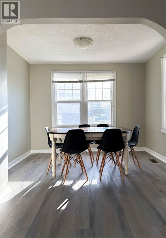 A dining room with a table and chairs.