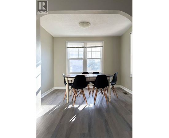 A dining room with a table and chairs.