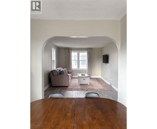 A living room with a brown couch and a white coffee table.