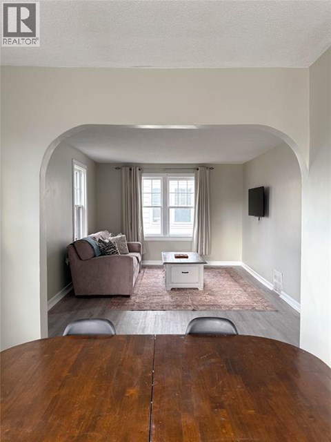 A living room with a brown couch and a white coffee table.