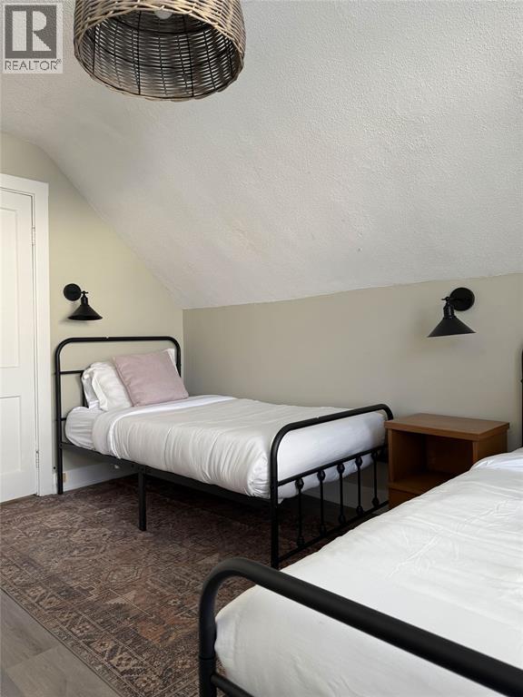 A bedroom with a bed and a wicker lamp.