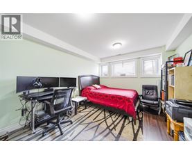 A bedroom with a bed, desk, and chair.