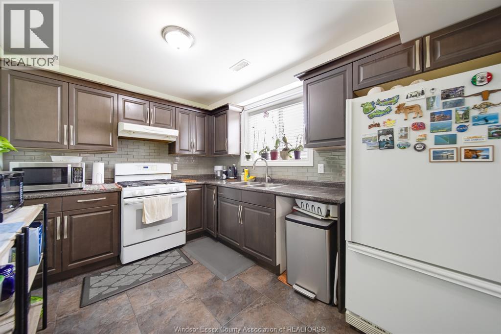 A kitchen with brown cabinets and a white fridge.