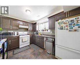 A kitchen with brown cabinets and a white fridge.
