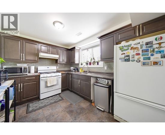 A kitchen with brown cabinets and a white fridge.