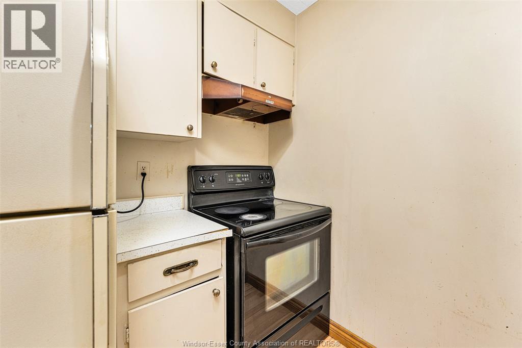 A black stove top oven in a kitchen with white cabinets.
