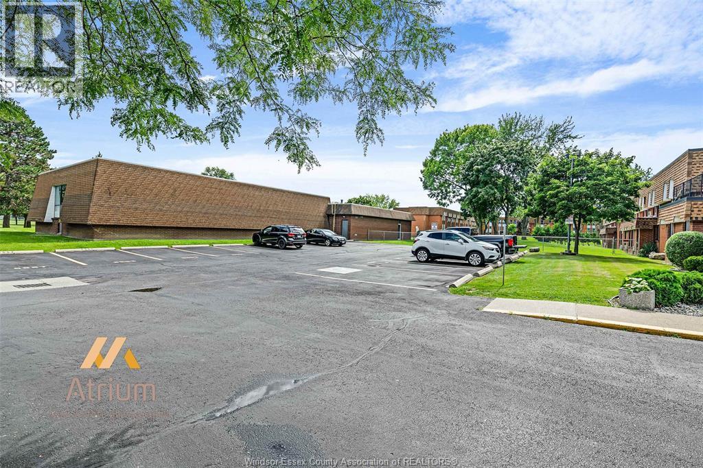 A parking lot with a building and cars parked in front.