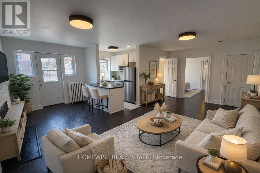 A well-lit, spacious living room with a kitchen in the background.