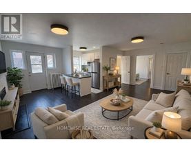 A well-lit, spacious living room with a kitchen in the background.