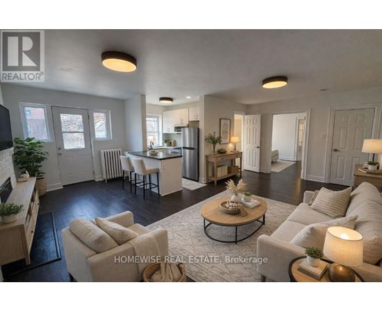 A well-lit, spacious living room with a kitchen in the background.