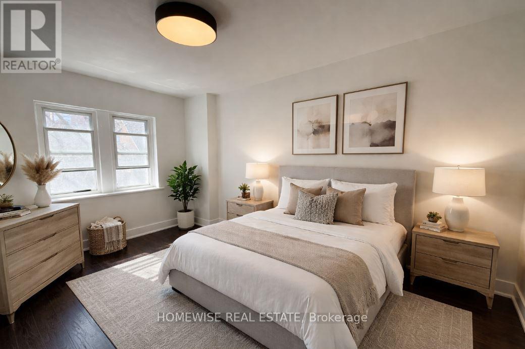 A well-lit bedroom with a large bed, two nightstands, and a plant.