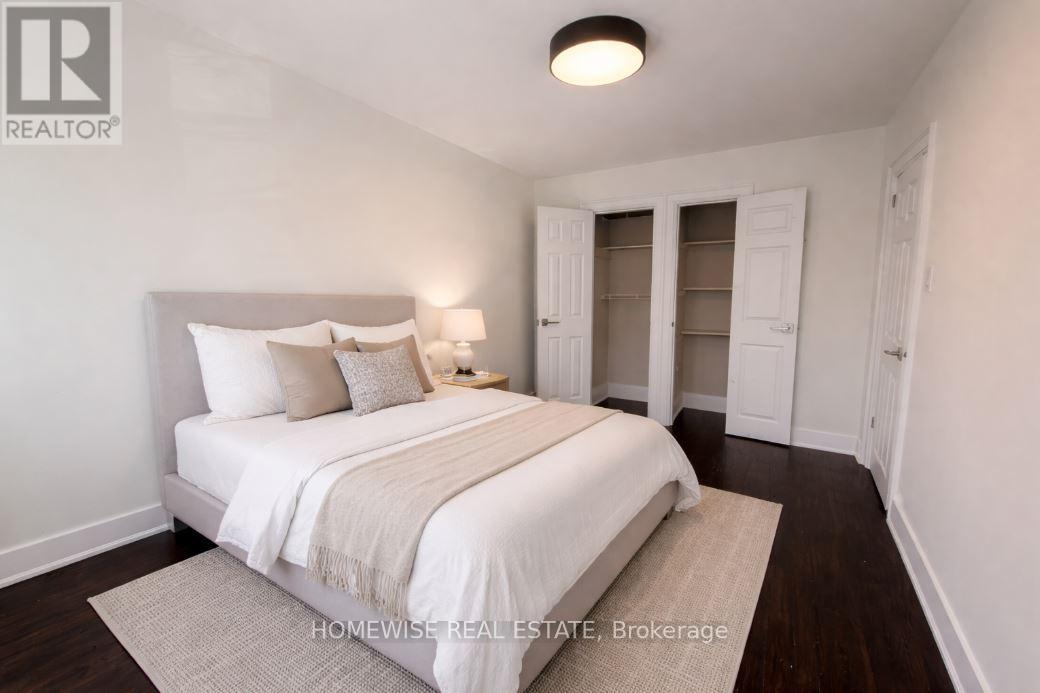 A bedroom with a bed, nightstand, and a lamp.