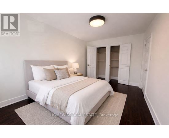 A bedroom with a bed, nightstand, and a lamp.
