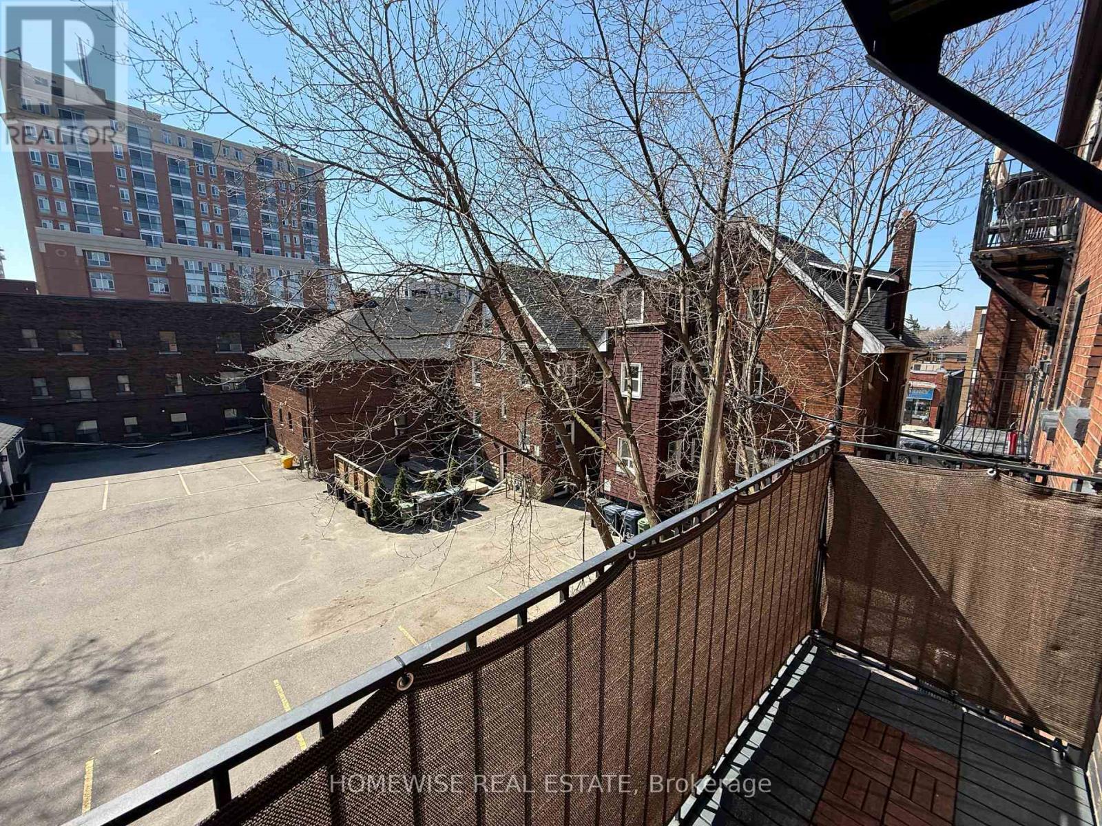 A brown building with a balcony overlooking a parking lot.