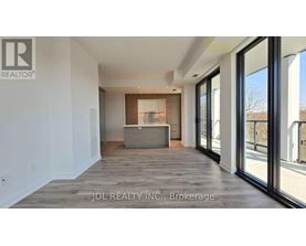 A spacious room with a large window and a wooden floor.