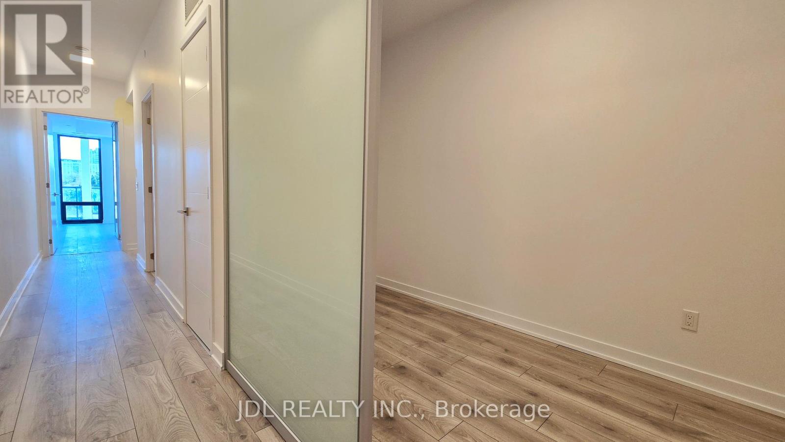 A hallway with a door at the end and a sign that says REALTOR.
