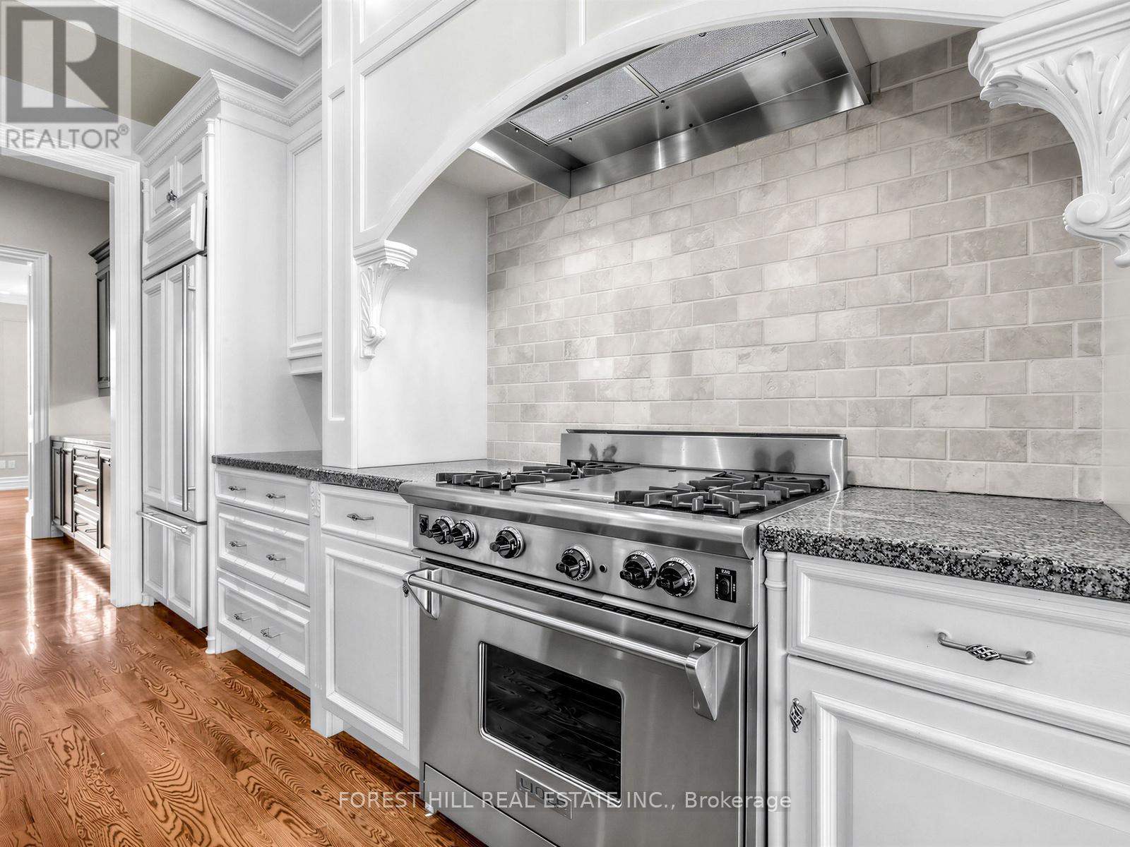 A kitchen with a stove top oven and a backsplash made of tiles.