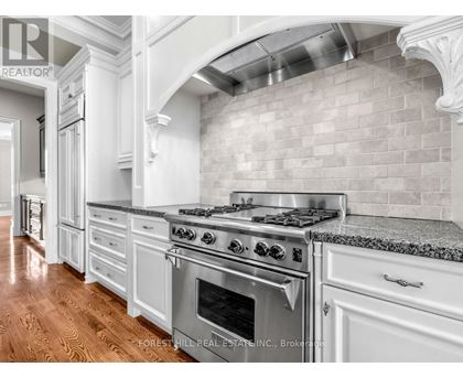 A kitchen with a stove top oven and a backsplash made of tiles.