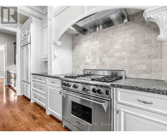 A kitchen with a stove top oven and a backsplash made of tiles.