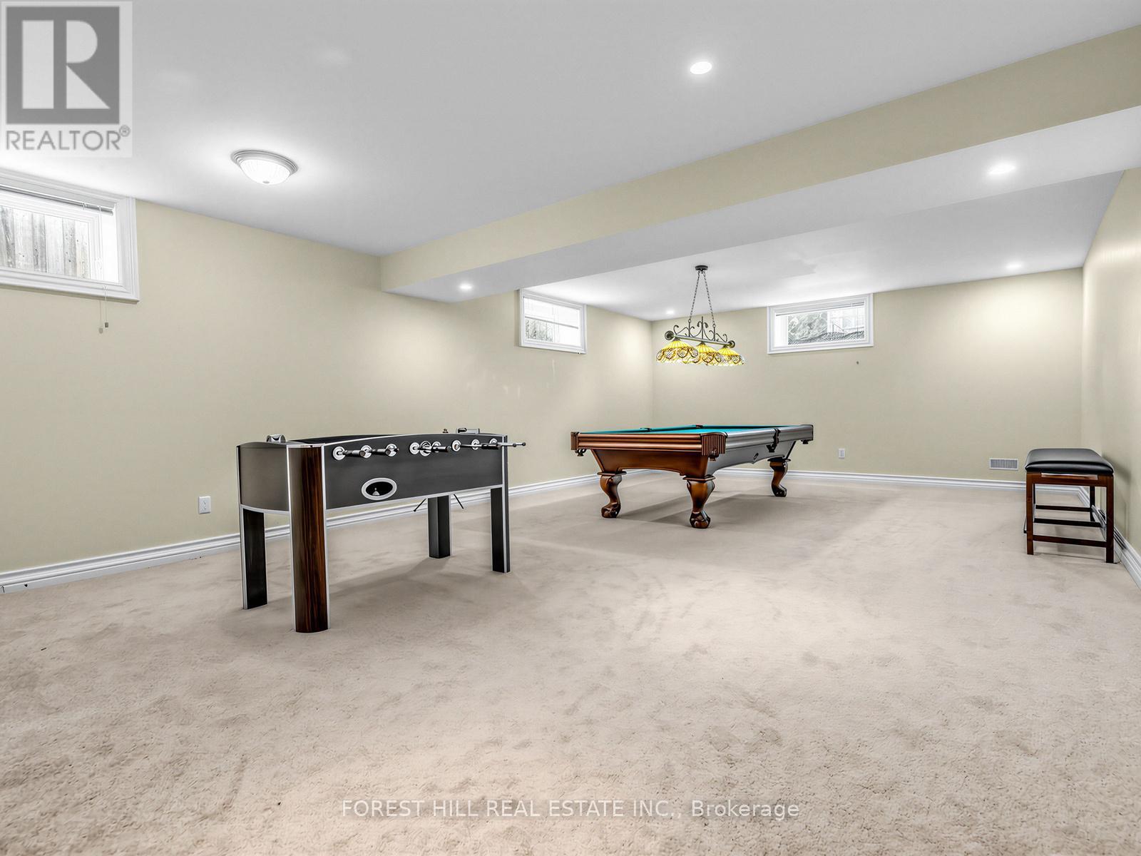 A room with a foosball table and a pool table.