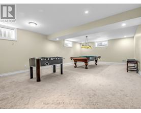 A room with a foosball table and a pool table.