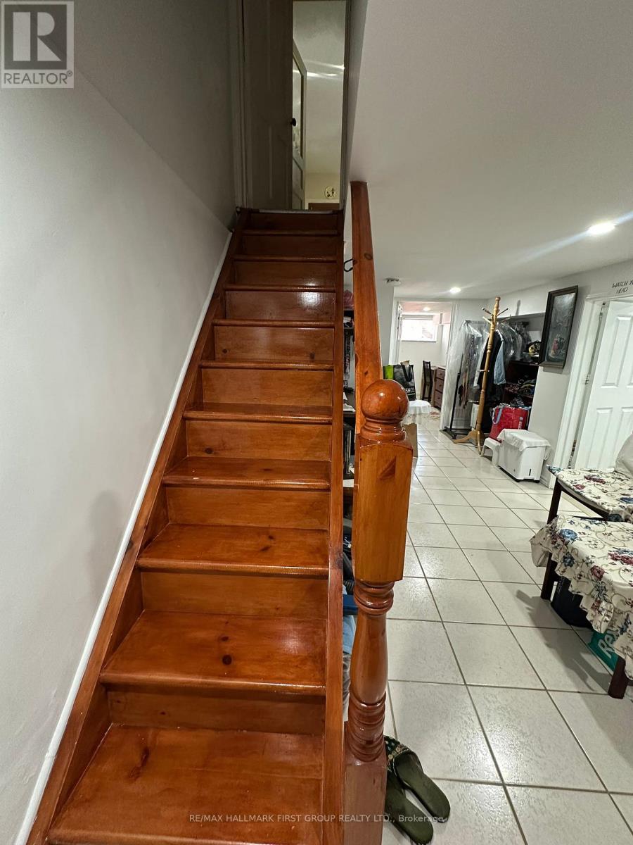 A wooden staircase leads up to a bedroom.