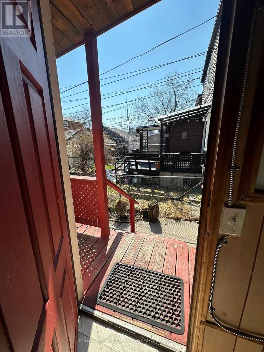 A view from inside a building looking out to a deck with a red railing.