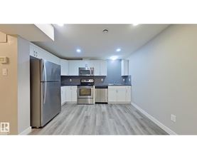 A kitchen with a refrigerator, microwave, oven, and sink.