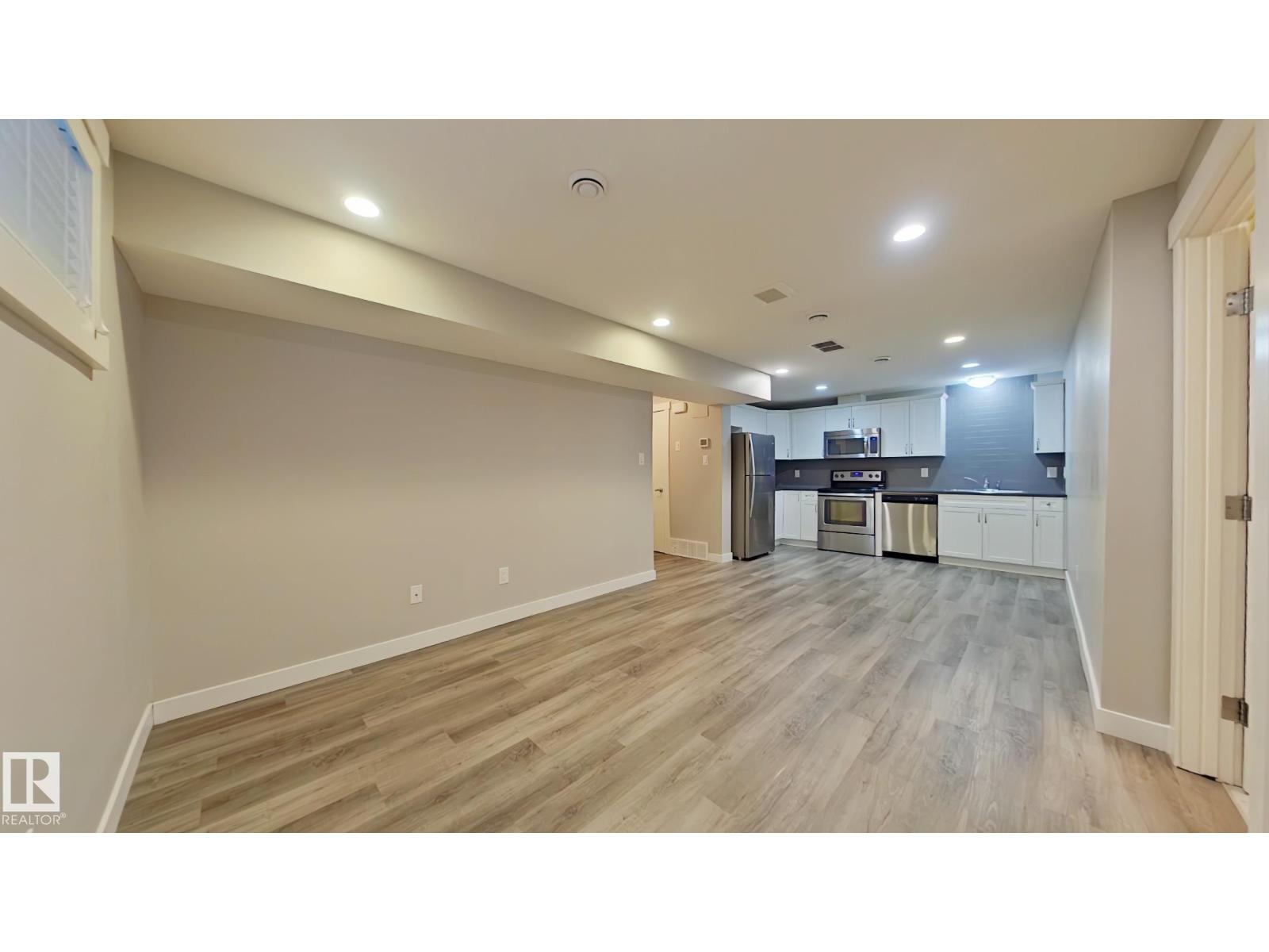 A spacious kitchen with a refrigerator, oven, and cabinets.