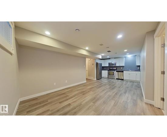 A spacious kitchen with a refrigerator, oven, and cabinets.