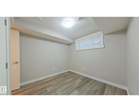 A room with wooden flooring and a window with blinds.