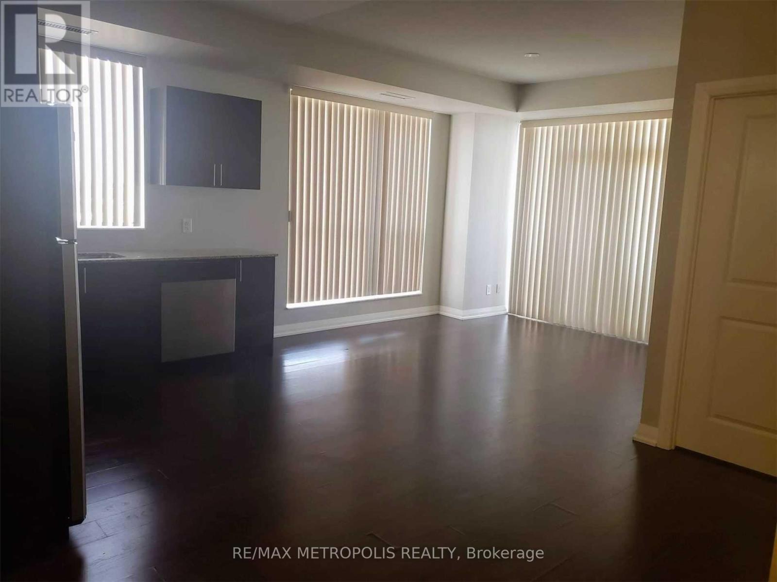 A spacious room with wooden floors and white walls.