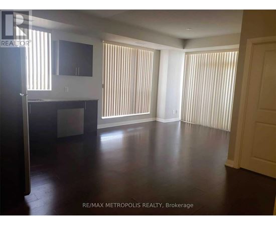 A spacious room with wooden floors and white walls.