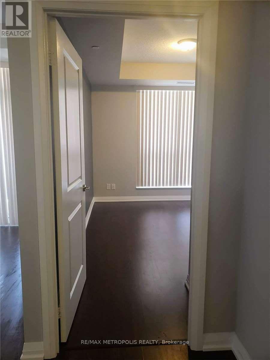 A hallway with a white door and a window with blinds.