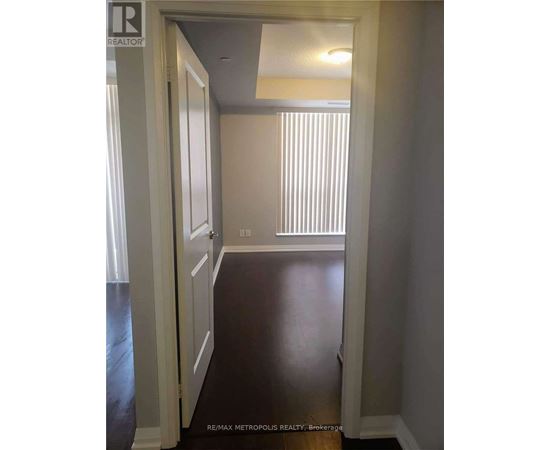 A hallway with a white door and a window with blinds.