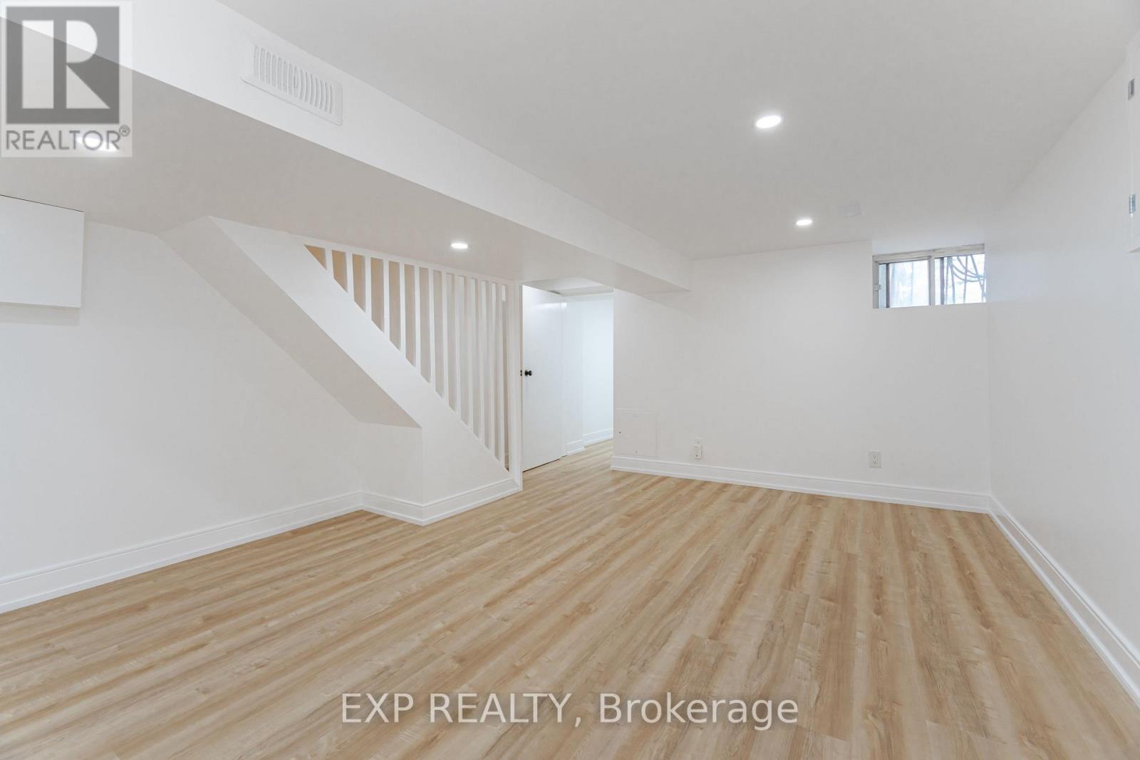 A room with wooden flooring and white walls.