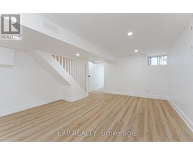A room with wooden flooring and white walls.