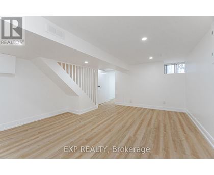 A room with wooden flooring and white walls.