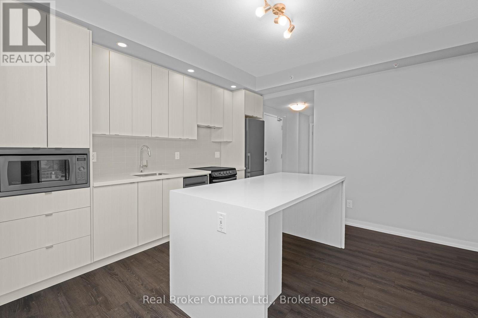 A white kitchen with a table and a microwave.