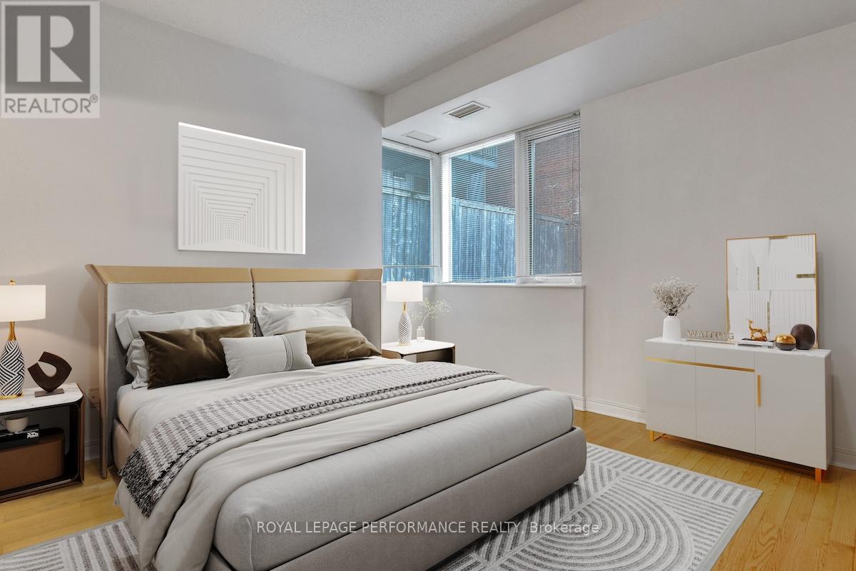 A bedroom with a large bed and a nightstand with a lamp.
