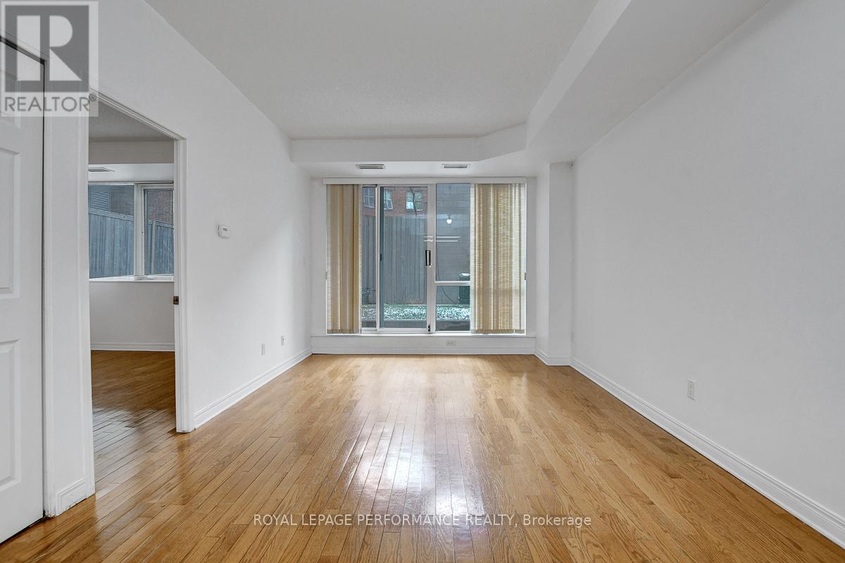 A spacious room with wooden floors and white walls.