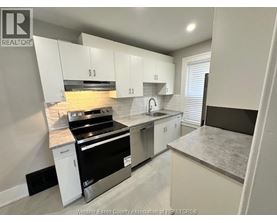 A kitchen with white cabinets and a black stove top oven.