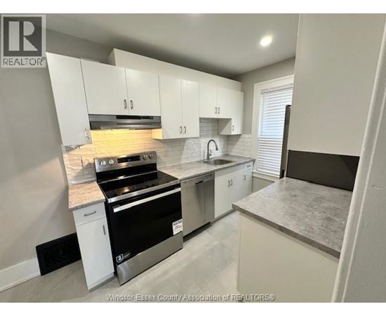 A kitchen with white cabinets and a black stove top oven.