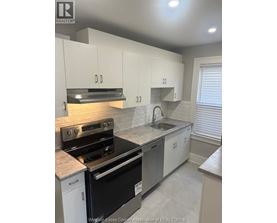 A kitchen with white cabinets and a black stove top oven.