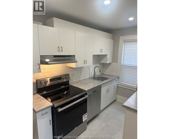 A kitchen with white cabinets and a black stove top oven.