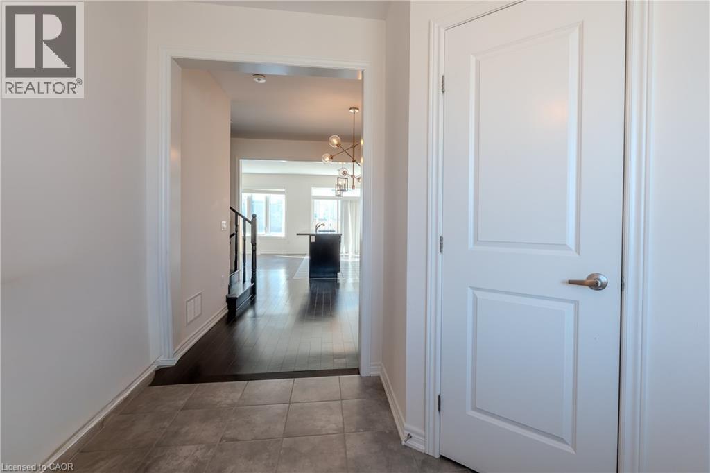 A hallway with a white door and a staircase.