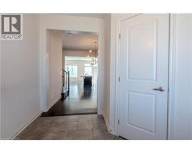 A hallway with a white door and a staircase.
