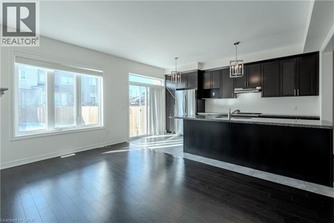 A modern kitchen with black cabinets and a large island.