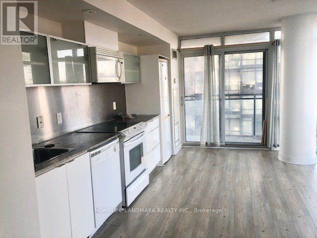 A kitchen with white cabinets and a black countertop.