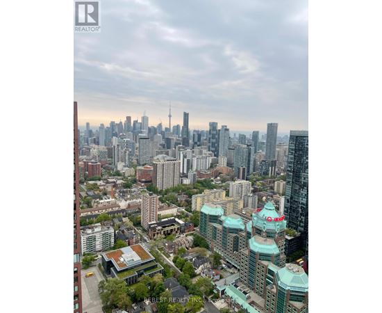 A cityscape with a mix of modern and older buildings, with a cloudy sky above.